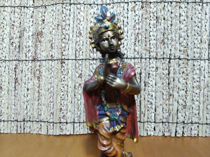 Estátua indiana de Krishna segurando uma rosa em resina pintada