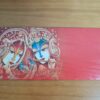 envelope luxuoso do Deus Krishna e sua Radharani (Radha), em vermelho, com detalhes dourados.