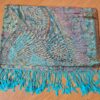 lenço indiano de tecido macio, com base em viscose e algodão, estampa arabescos, com franjas nas pontas, dupla face, azul claro e tons suaves