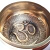 Tigela tibetana com 7 ligas dourada símbolo OM 10,5cm